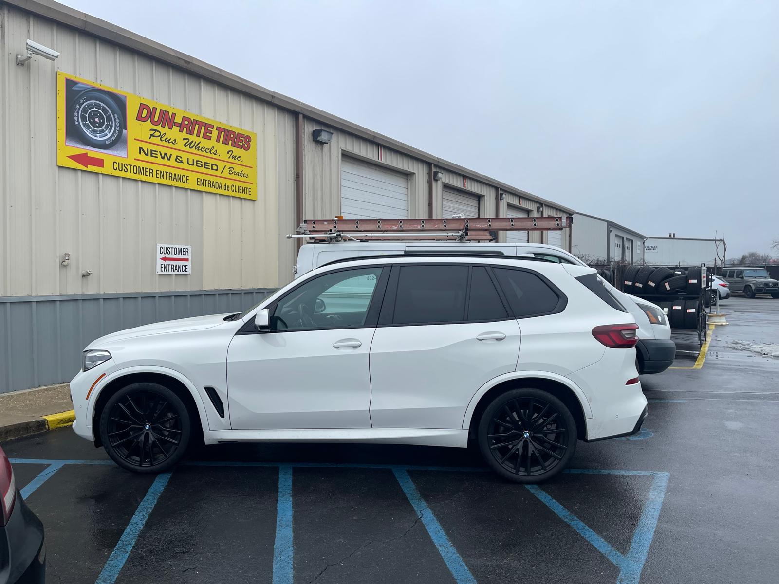 White BMW X5 with black wheels at Dun-Rite storefront