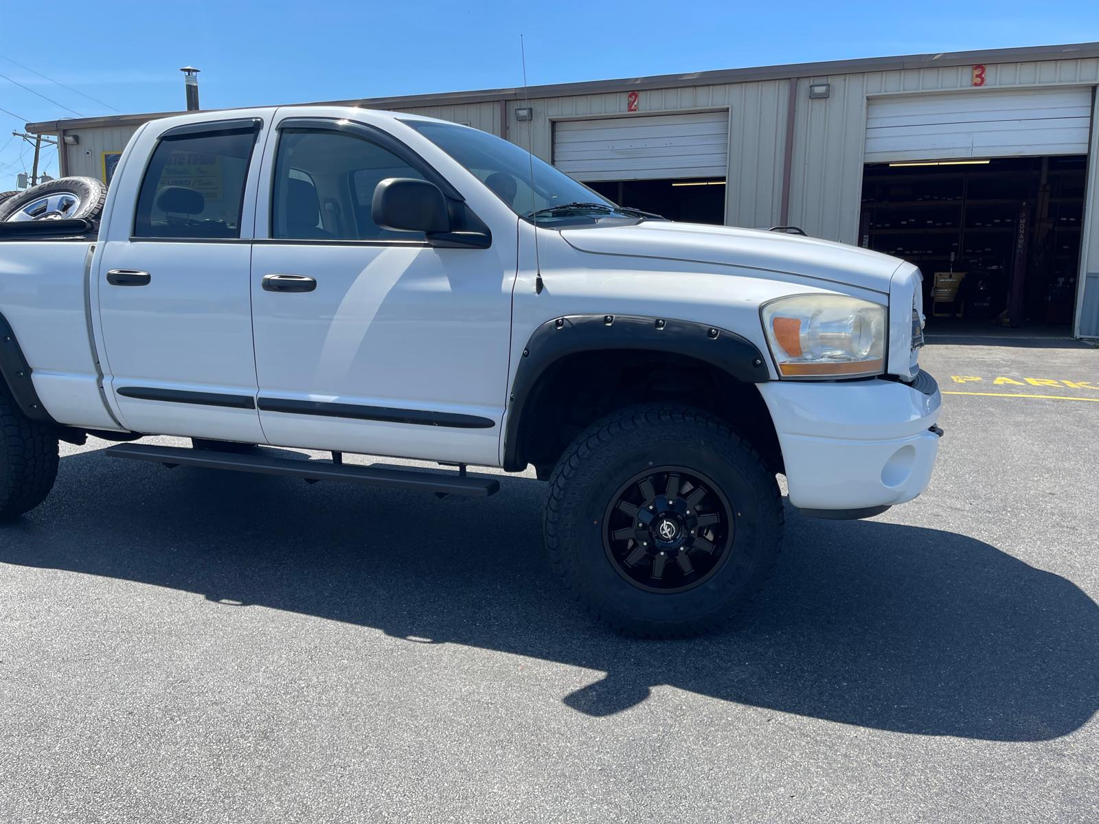 White Dodge Ram with off-road tires and black wheels