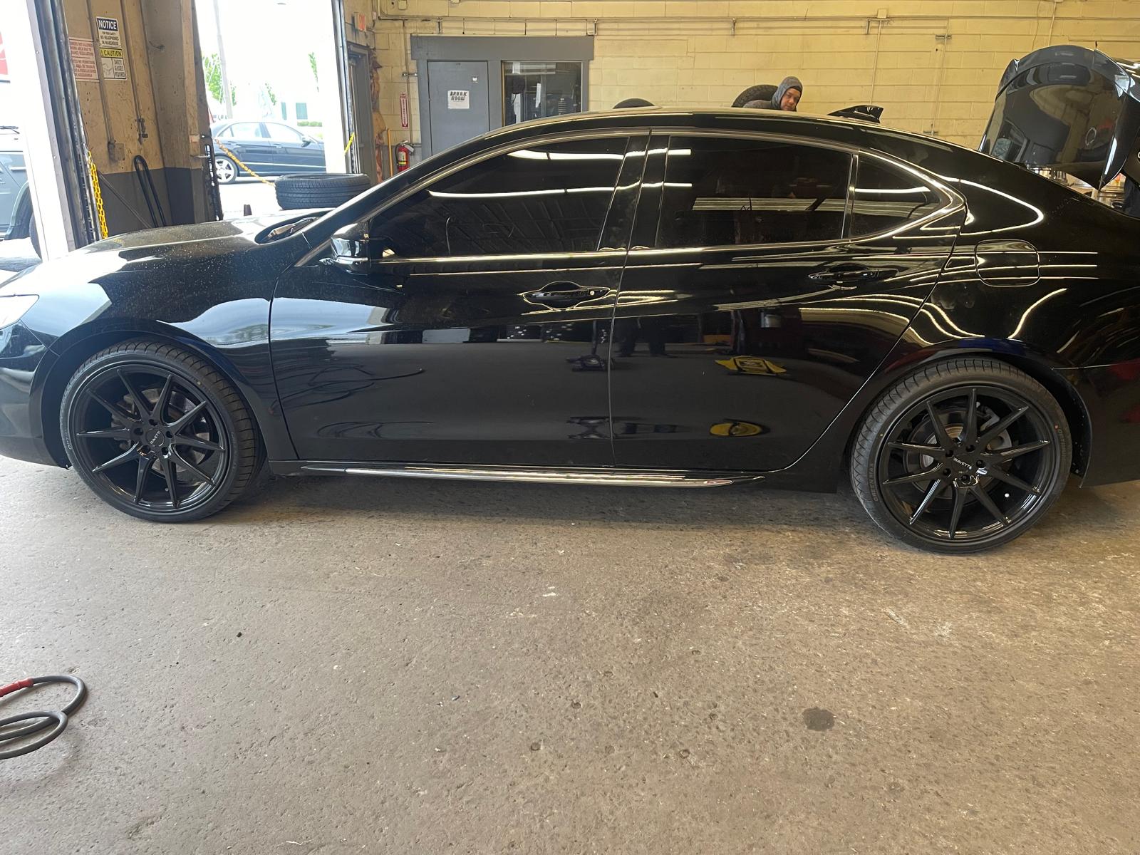 Black Porsche Cayenne on lift for service